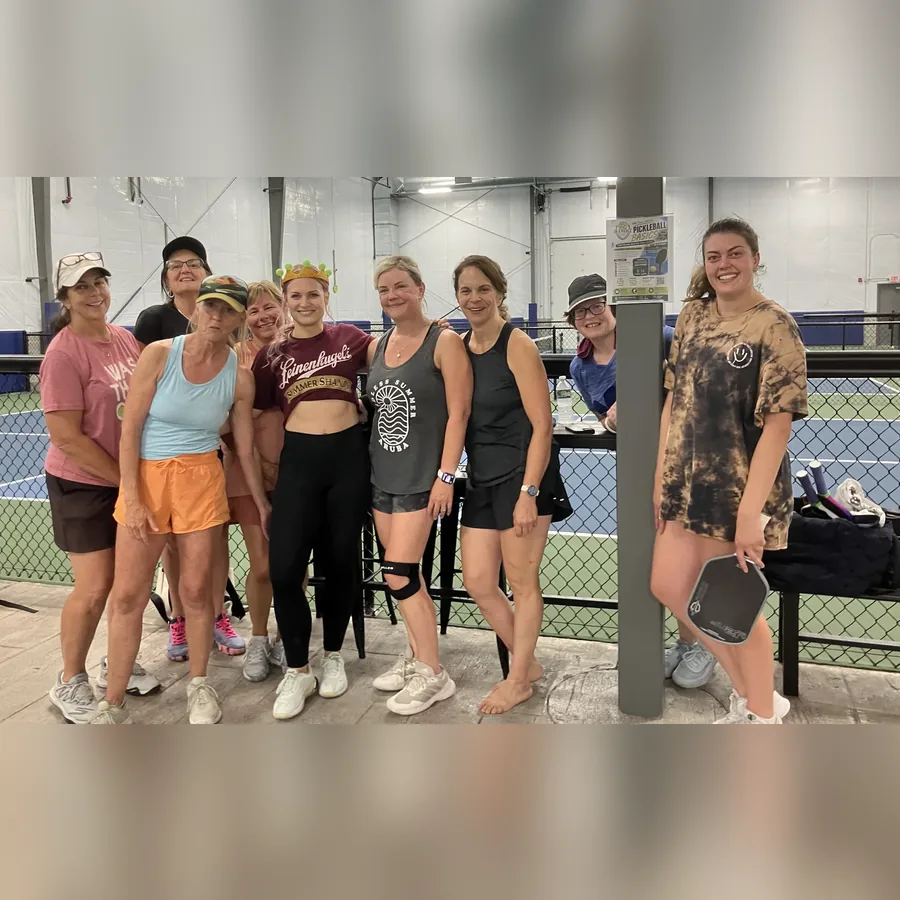 A group of players posing courtside with paddles after a session